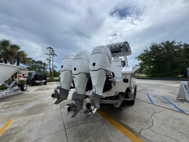 Slide: The Image of 2022 Fountain 38 CC boat with triple outboard engines in a parking lot. - 13