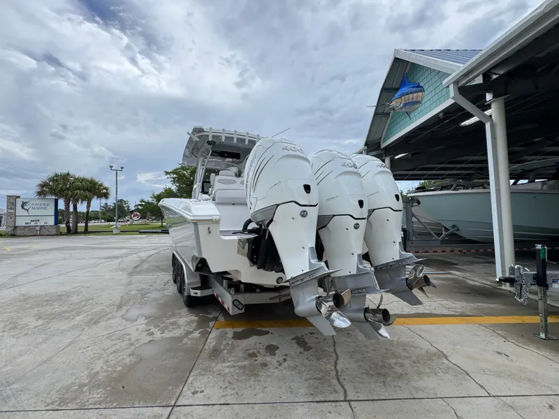 Slide: The Image of 2022 Fountain 38 CC boat with triple outboard engines in a marina setting. - 15