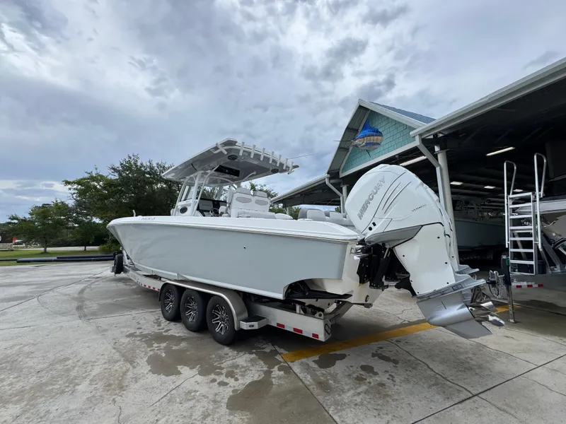 Slide: The Image of 2022 Fountain 38 CC boat with Mercury engines on a trailer, parked near a building. - 16