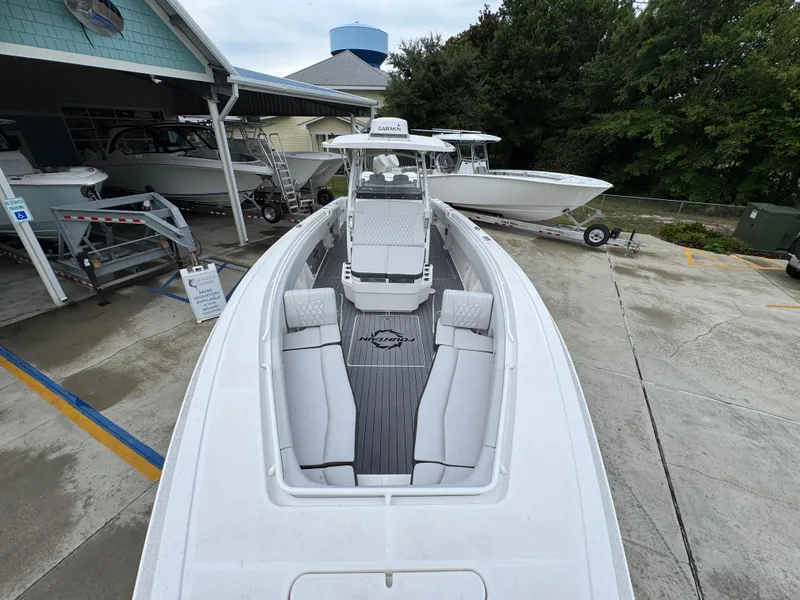 Slide: The Image of 2022 Fountain 38 CC boat with sleek design, docked at a marina. - 21