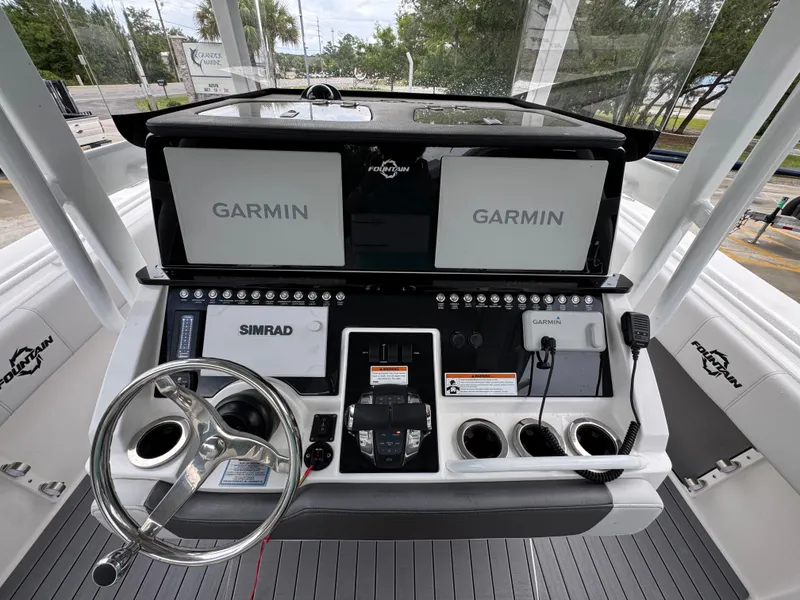 Slide: The Image of 2022 Fountain 38 CC boat dashboard with Garmin and Simrad navigation systems. - 32