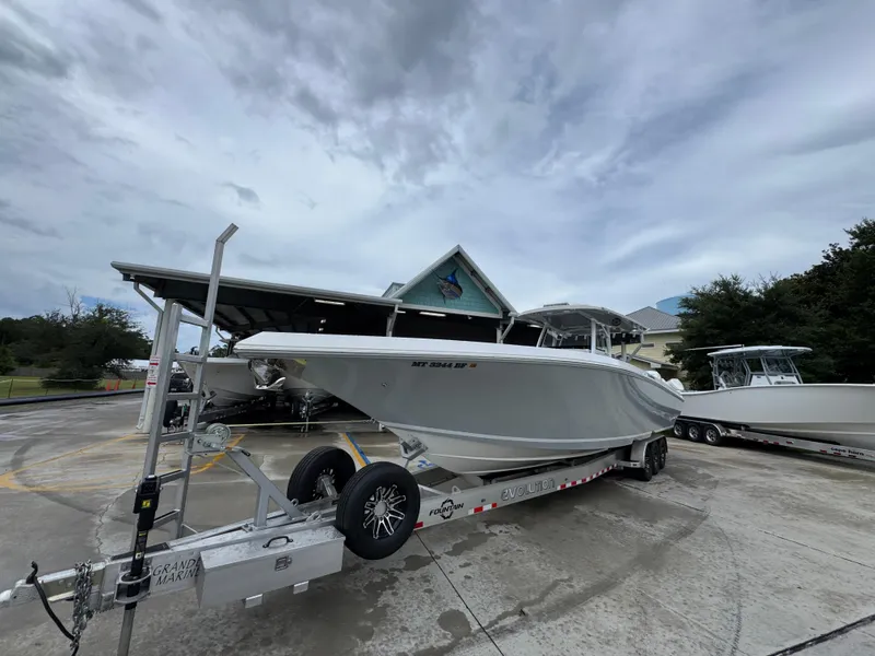 Slide: The Image of 2022 Fountain 38 CC boat on trailer, parked outdoors under cloudy sky. - 4