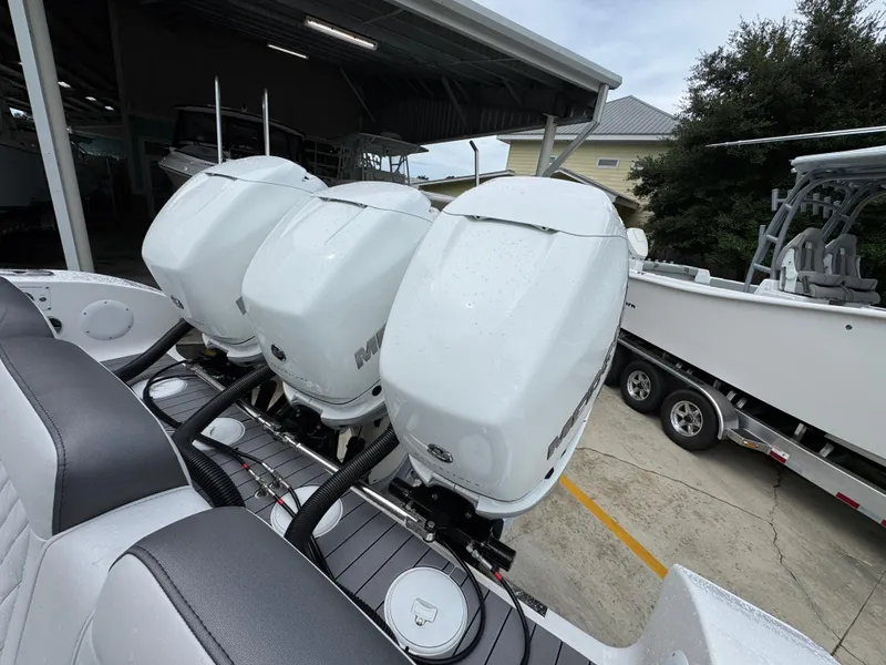 Slide: The Image of Triple outboard motors on a 2022 Fountain 38 CC boat in a marina setting. - 41