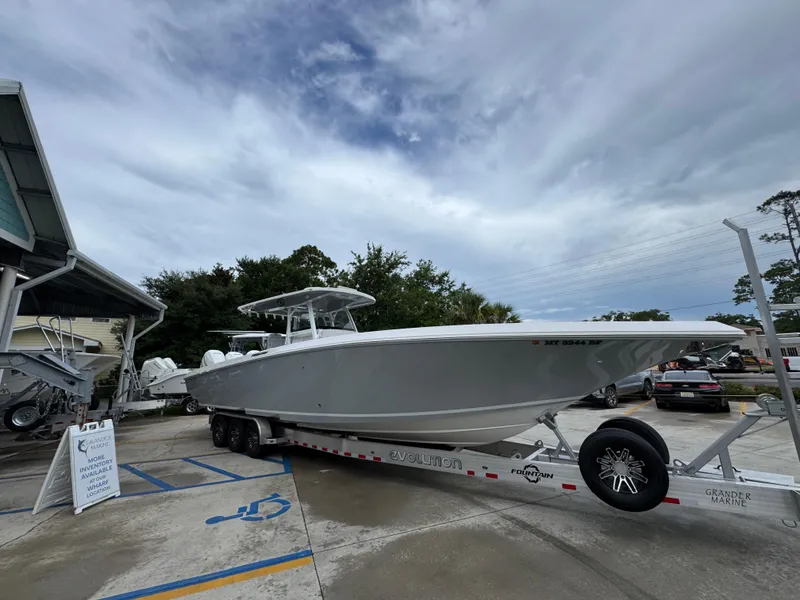 Slide: The Image of 2022 Fountain 38 CC boat on trailer at marina under cloudy sky. - 9