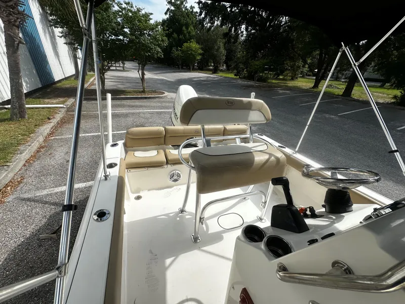 Slide: The Image of 2019 Key West 189FS boat interior with seating and steering wheel in a parking lot. - 3