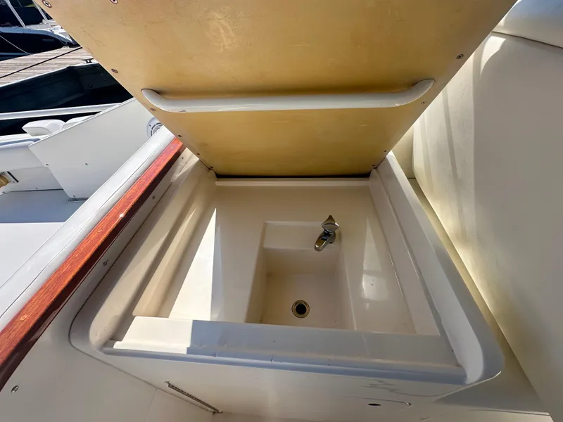 Slide: The Image of Open storage compartment on 1988 Bertram 28 Moppie boat, featuring a built-in sink. - 16