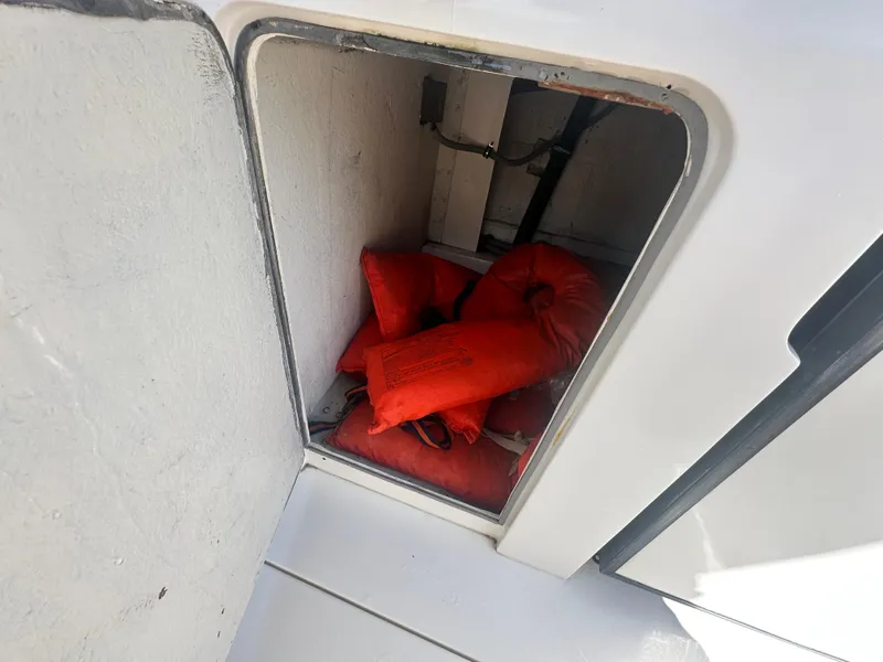 Slide: The Image of Storage compartment with orange life jackets on a 1988 Bertram 28 Moppie boat. - 19