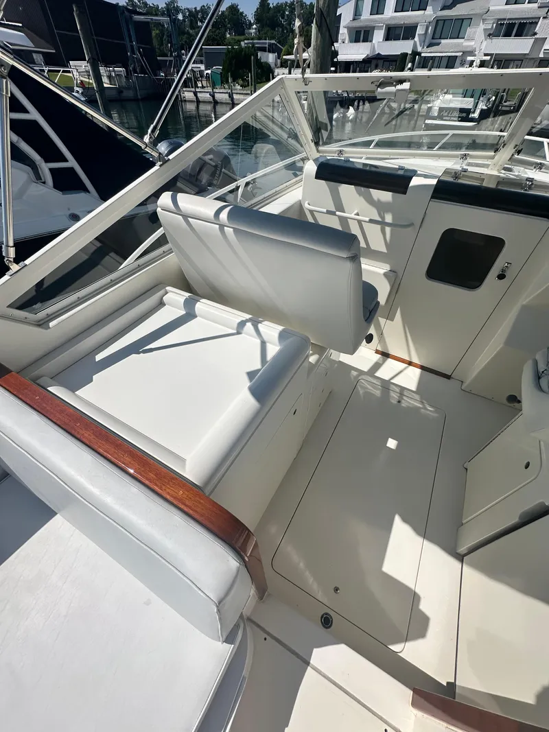 Slide: The Image of 1988 Bertram 28 Moppie boat interior with white seating and wooden accents. - 5