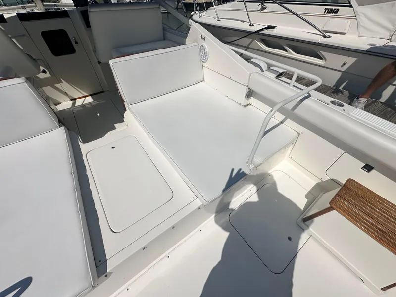 Slide: The Image of 1988 Bertram 28 Moppie boat interior with white seating and deck details. - 7