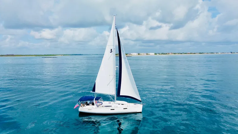 The Image of Sailing yacht Beneteau Oceanis 45, 2015 model, cruising on calm blue waters under a cloudy sky. - 1
