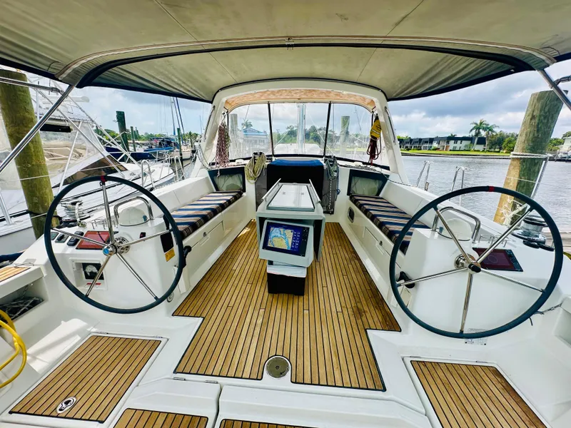 Slide: The Image of Cockpit of 2015 Beneteau Oceanis 45 sailboat with dual steering wheels and teak flooring. - 26