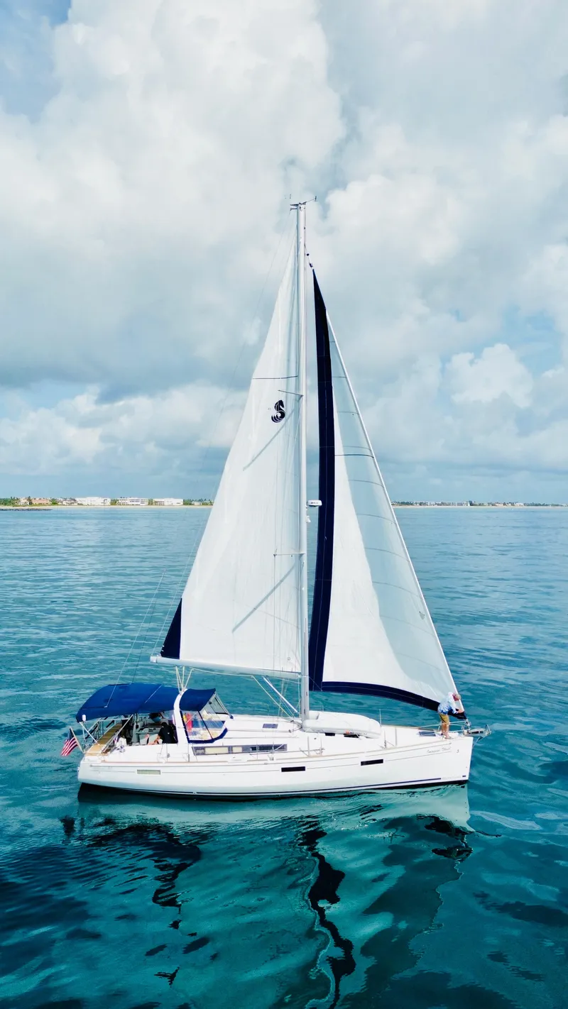Slide: The Image of 2015 Beneteau Oceanis 45 sailing on calm blue waters under a cloudy sky. - 7