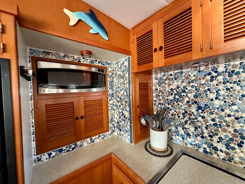 Slide: The Image of 2008 Kadey-Krogen 44 yacht interior with kitchen, decorative seashells, and coastal-themed decor. - 20