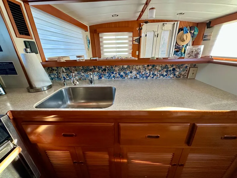 Slide: The Image of Kitchen area of 2008 Kadey-Krogen 44 yacht with mosaic backsplash and wooden cabinets. - 22