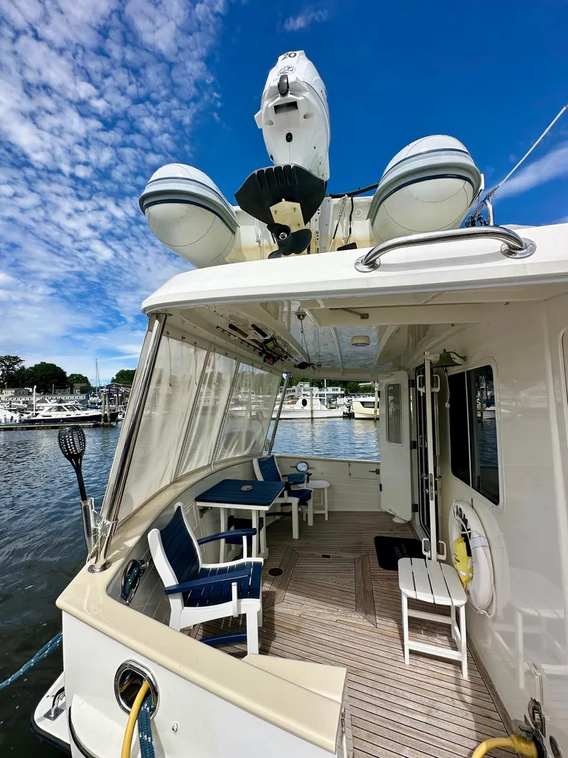 Slide: The Image of 2008 Kadey-Krogen 44 yacht docked in a marina with cityscape background. - 58
