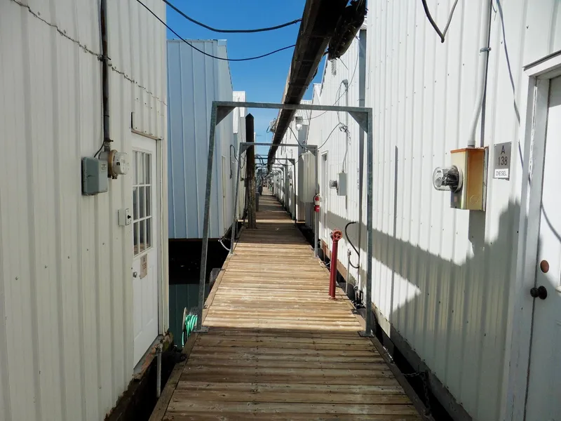 Slide: The Image of Wooden dock between white boathouses, Custom Boathouse #A138, 2012. - 2
