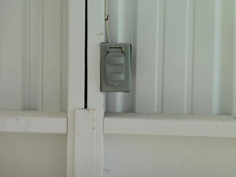 Slide: The Image of White boathouse wall with a closed electrical outlet cover, Custom Boathouse #A138, 2012. - 6
