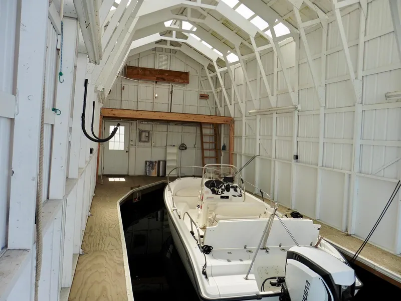 Slide: The Image of Interior of Custom Boathouse #A138, 2012, with a docked motorboat inside. - 8