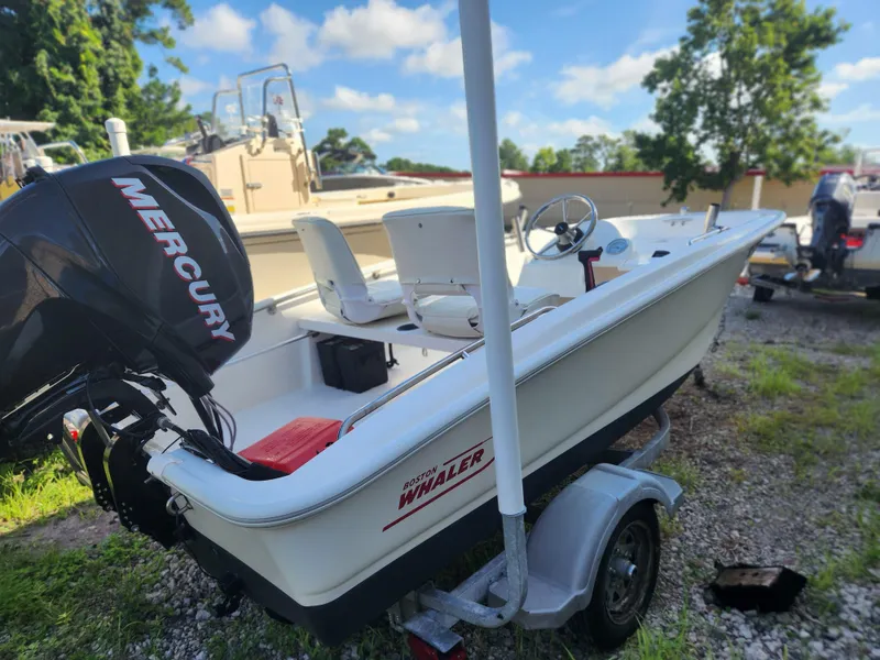 Slide: The Image of 2011 Boston Whaler 130 Super Sport boat with Mercury engine on trailer. - 2