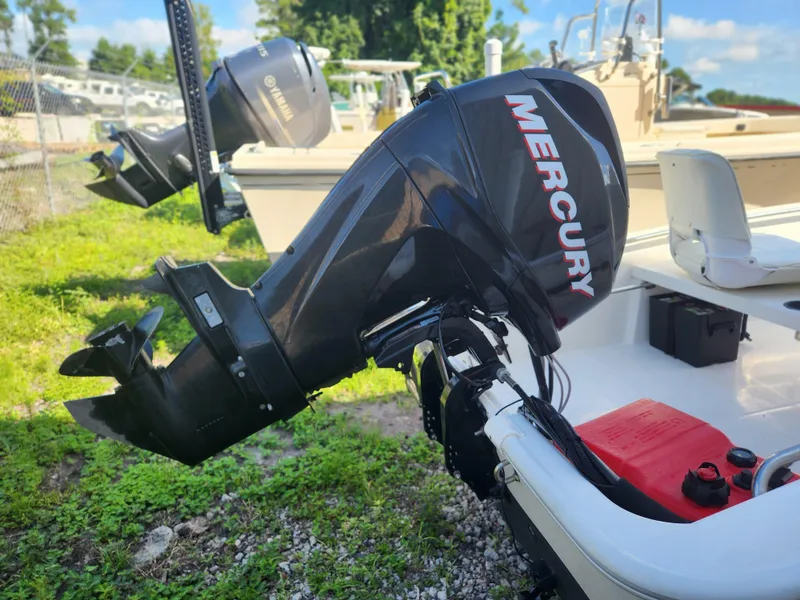 Slide: The Image of 2011 Boston Whaler 130 Super Sport with Mercury outboard motor, parked on grass. - 3