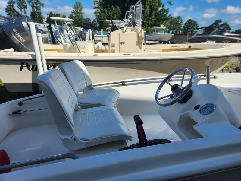 Slide: The Image of 2011 Boston Whaler 130 Super Sport boat interior with steering wheel and seats. - 4