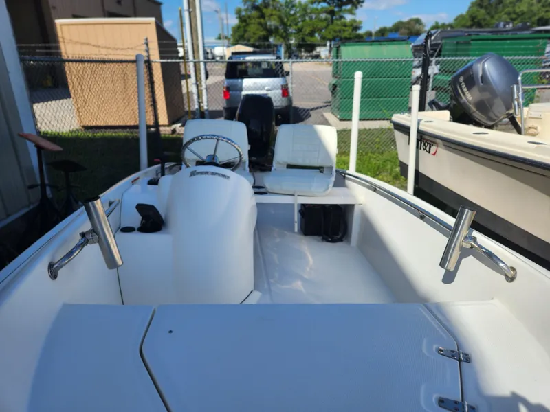 Slide: The Image of 2011 Boston Whaler 130 Super Sport boat interior with steering wheel and rod holders. - 6