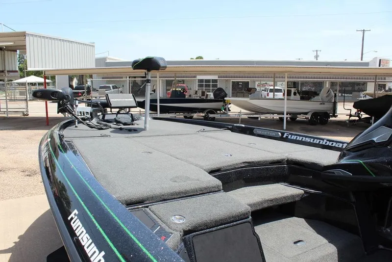 Slide: The Image of 2020 Skeeter FXR21 boat with spacious deck, parked at a dealership. - 15