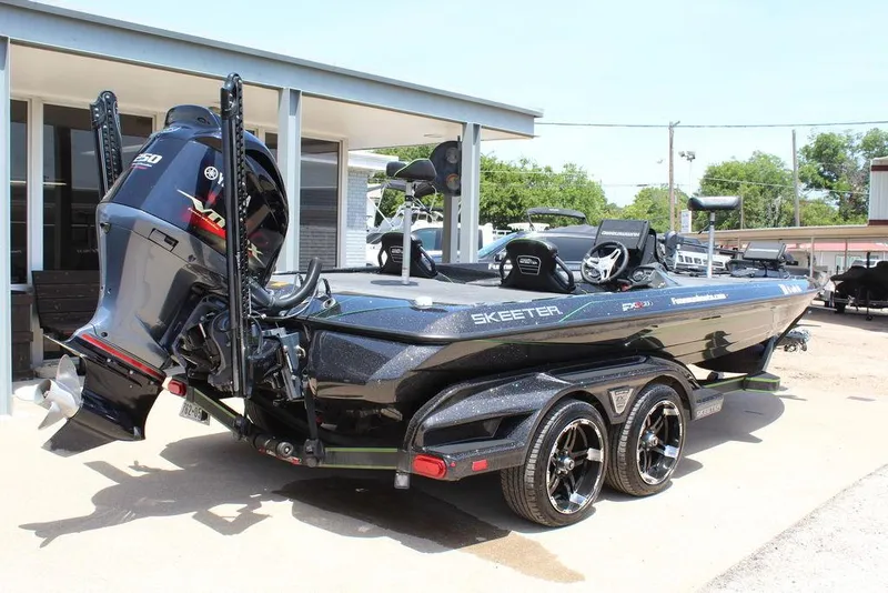 Slide: The Image of 2020 Skeeter FXR21 boat with Yamaha engine on a trailer, parked outdoors. - 4