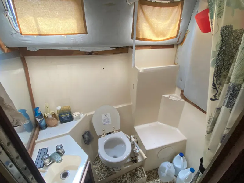 Slide: The Image of 1986 Albin 34 Family Cruiser bathroom with toilet, sink, and storage shelves. - 10