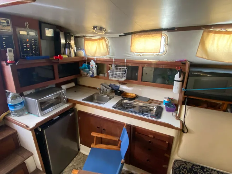 Slide: The Image of 1986 Albin 34 Family Cruiser kitchen with stove, sink, and storage cabinets. - 11