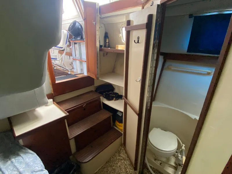 Slide: The Image of 1986 Albin 34 Family Cruiser interior with stairs, storage, and compact bathroom. - 16