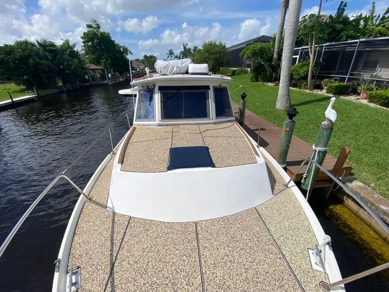 Slide: The Image of 1986 Albin 34 Family Cruiser docked by a lush, green canal. - 3