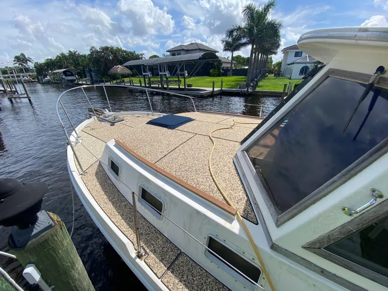 Slide: The Image of 1986 Albin 34 Family Cruiser docked by a scenic waterfront. - 5