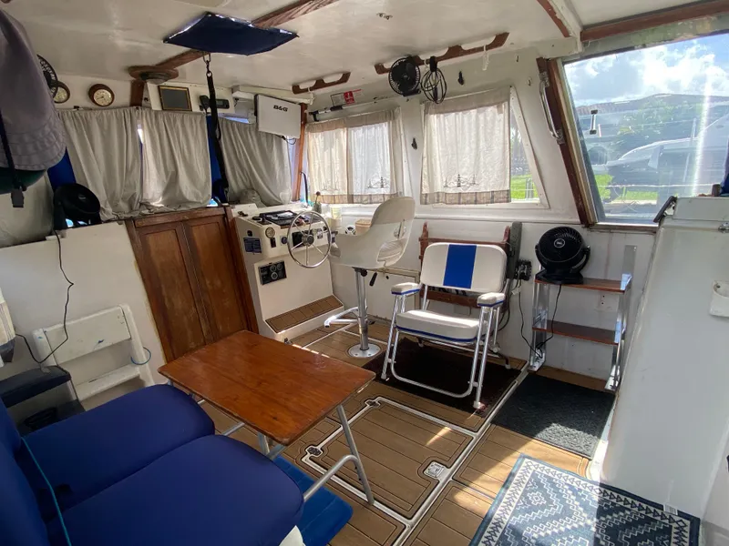 Slide: The Image of Interior of 1986 Albin 34 Family Cruiser with helm, seating, and wooden accents. - 7