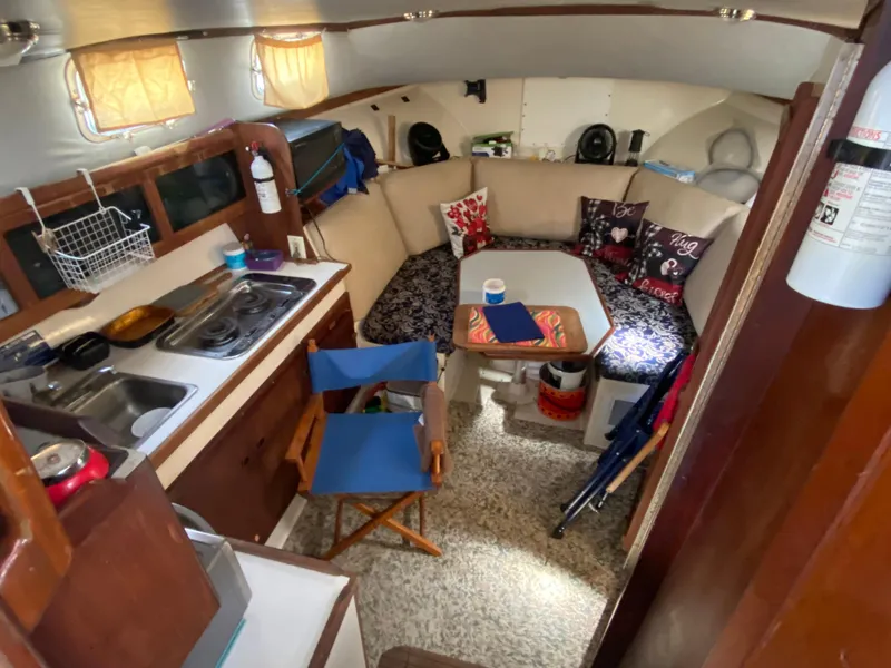 Slide: The Image of Interior of 1986 Albin 34 Family Cruiser with cozy seating and compact kitchen area. - 9