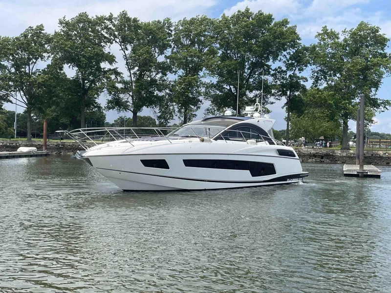 Slide: The Image of 2015 Sunseeker San Remo 48 yacht on calm water, surrounded by trees. - 4