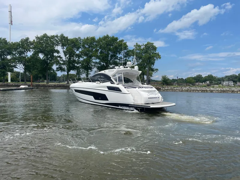 Slide: The Image of 2015 Sunseeker San Remo 48 yacht cruising on a calm river under a blue sky. - 6