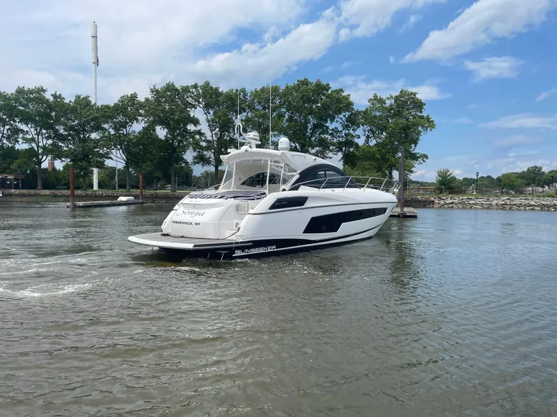 Slide: The Image of 2015 Sunseeker San Remo 48 yacht cruising on a calm river with trees in the background. - 7