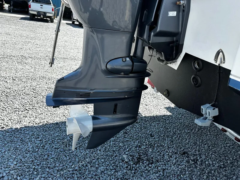 Slide: The Image of Outboard motor of 2013 Sea Hunt Triton 202 Center Console on gravel surface. - 13