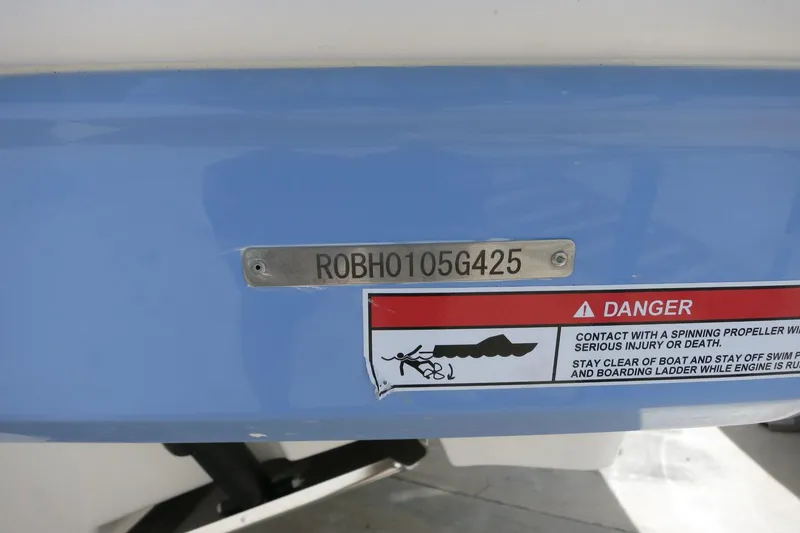 Slide: The Image of 2025 Robalo R317 Dual Console boat with HIN and safety warning label. - 10