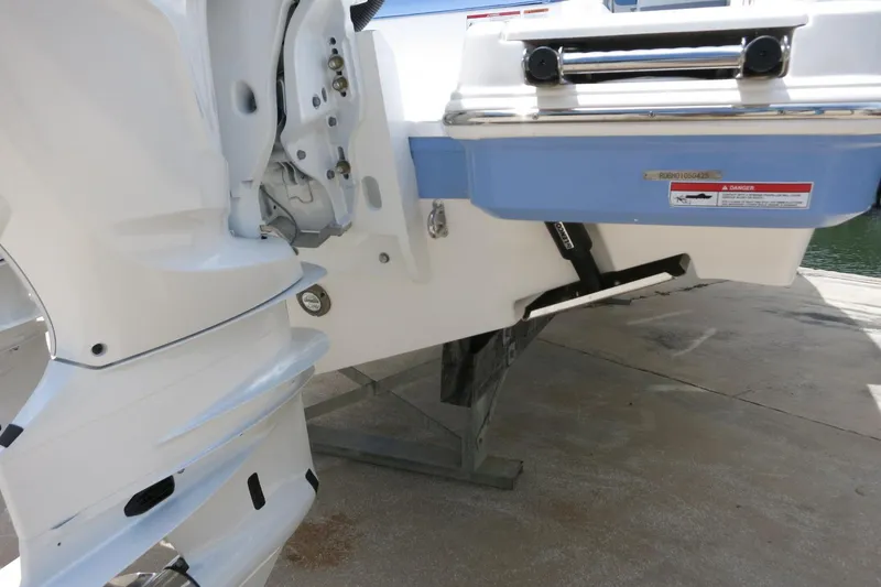 Slide: The Image of 2025 Robalo R317 Dual Console boat stern detail with outboard motor and warning label. - 12