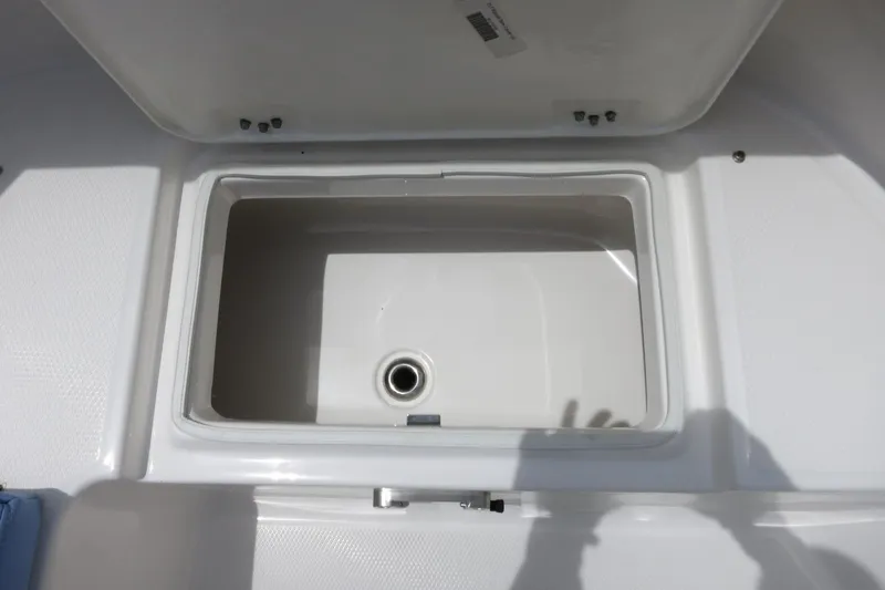 Slide: The Image of Open storage compartment on 2025 Robalo R317 Dual Console boat. - 16