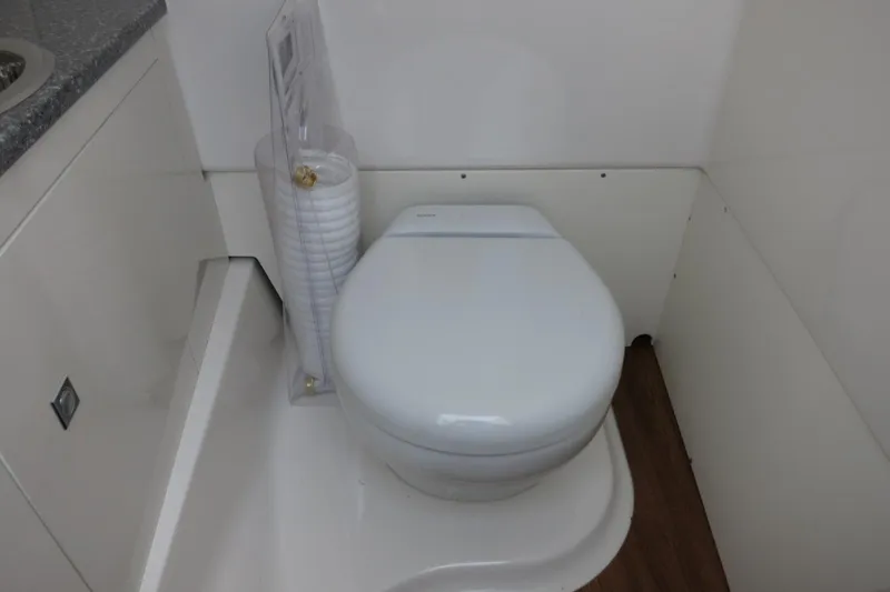 Slide: The Image of 2025 Robalo R317 Dual Console boat bathroom with modern toilet and compact design. - 20