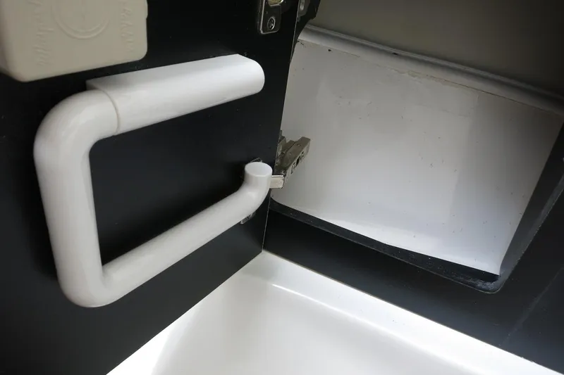 Slide: The Image of White handle and open compartment on 2025 Robalo R317 Dual Console boat. - 21