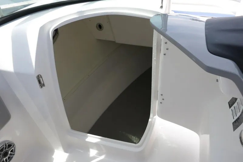 Slide: The Image of 2025 Robalo R317 Dual Console interior storage compartment, white finish, open door view. - 26