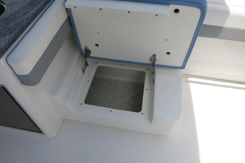 Slide: The Image of 2025 Robalo R317 Dual Console storage compartment with open lid, showcasing interior design. - 35