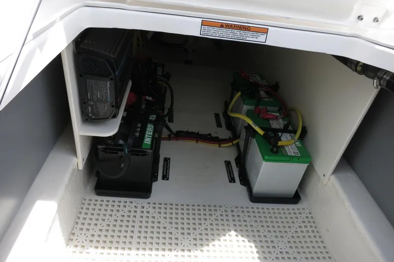 Slide: The Image of Battery compartment of 2025 Robalo R317 Dual Console boat, featuring multiple batteries and wiring. - 36