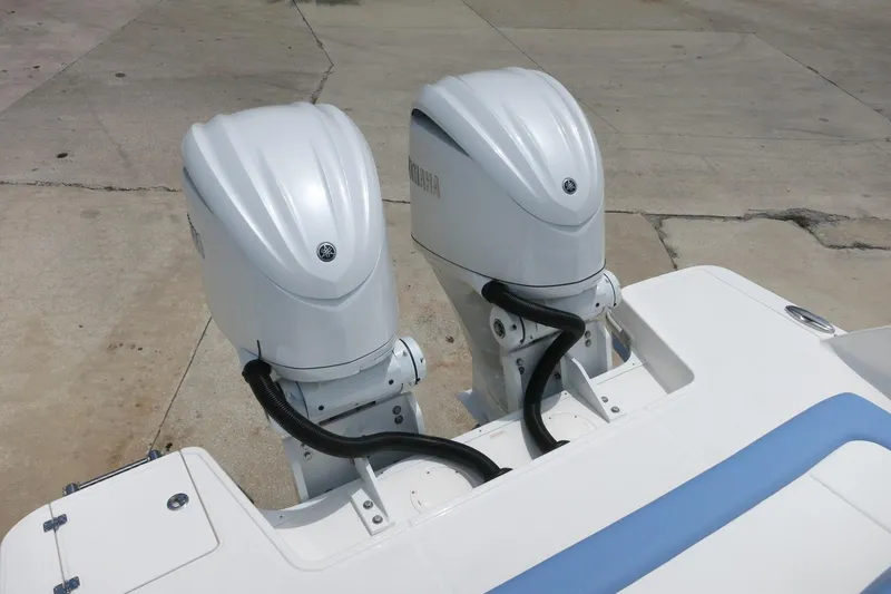 Slide: The Image of 2025 Robalo R317 Dual Console with twin outboard engines on a concrete surface. - 39