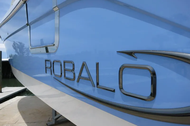 Slide: The Image of 2025 Robalo R317 Dual Console boat side view with logo. - 8