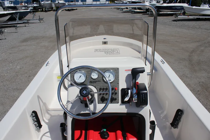 Slide: The Image of 2025 Carolina Skiff E18 JVX CC boat dashboard with steering wheel and controls. - 10